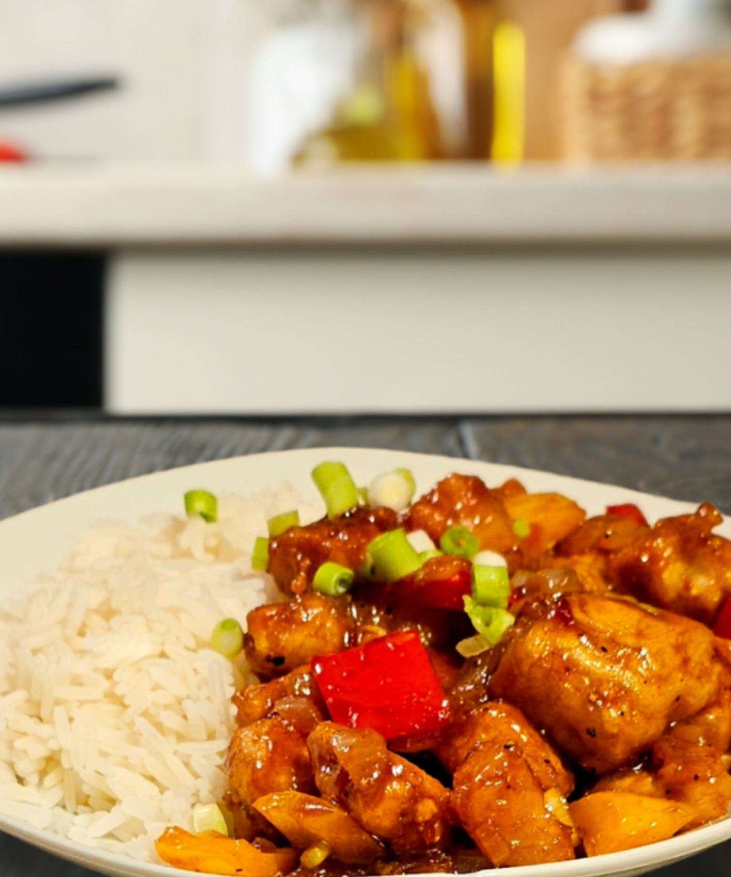 Vegan kung pao dish with stir-fried tofu, vibrant vegetables, cashews, and pineapple in a savory, spicy sauce served on a plate.